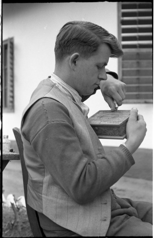 Fiatal férfi egy fadobozt faragással díszít (MTA BTK Néprajztudományi Intézet CC BY-NC-SA)