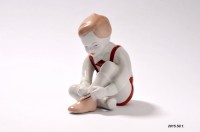 Porcelán dísztárgy, cipőfűzőt kötő kisfiú, Aquincum Porcelángyár terméke
