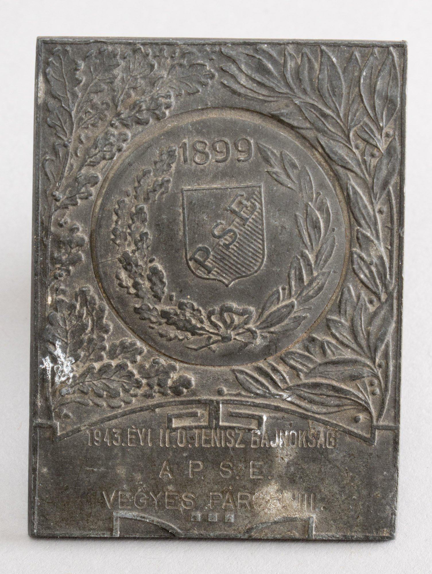 Emlékplakett (bronz) „PSE 1899 1943. ÉVI II. O. TENISZBAJNOKSÁG A P.S.E. VEGYES PÁROS III.” (Postamúzeum CC BY-NC-SA)